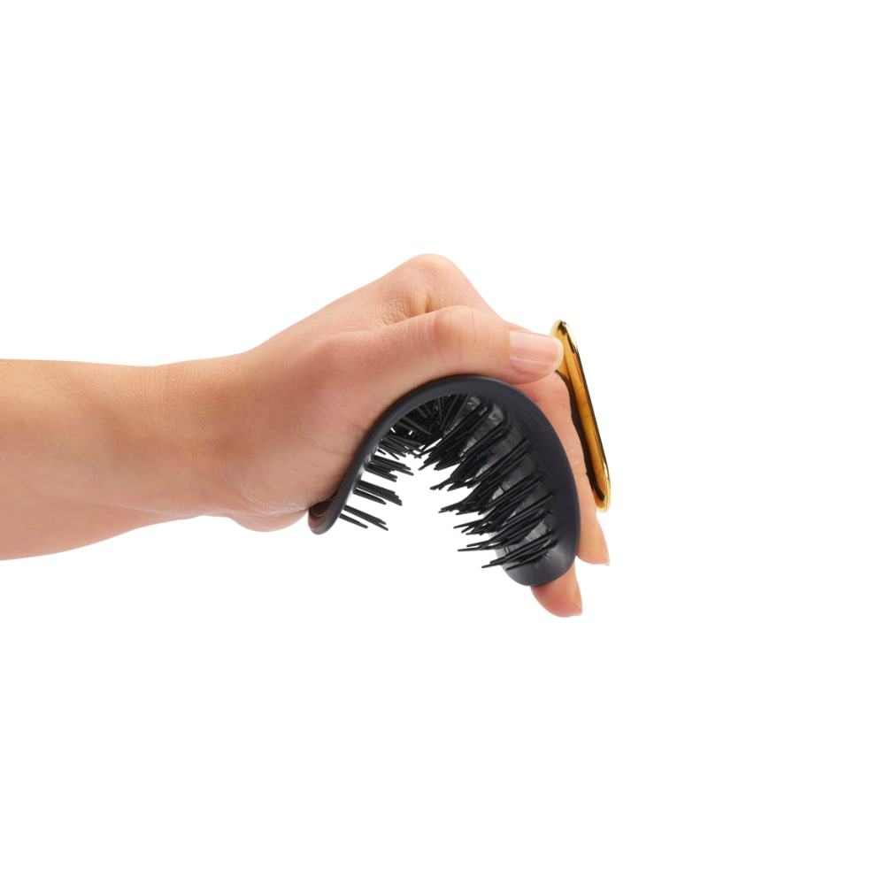 Die Manta-Haarbürste ist flexibel und Sie halten sie zwischen zwei Fingern