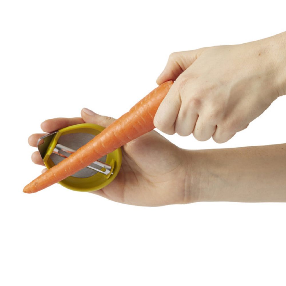 Der Handschäler sitzt in Ihrer Hand, um Obst und Gemüse zu schälen